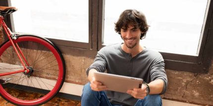 Man sitting in front of window with tablet stage